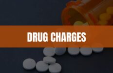 Text that says Drug Charges with an image of pills and a pill bottle in the background