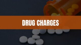 Text that says Drug Charges with an image of pills and a pill bottle in the background