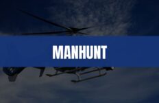 Text that says Manhunt on a blue rectangle with a helicopter in the air in the background