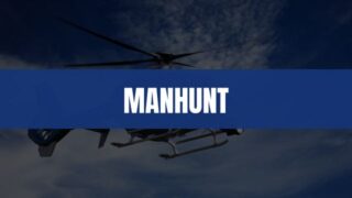 Text that says Manhunt on a blue rectangle with a helicopter in the air in the background