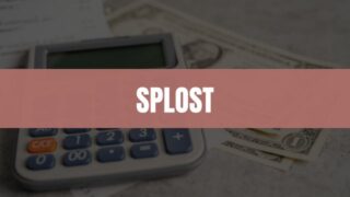 Text that says SPLOST on a penny colored rectangle with a calculator, dollar bills, and receipts in the background