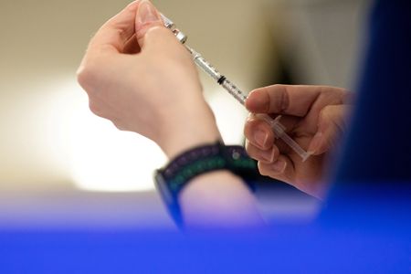 FILE PHOTO: A nurse fills up a syringe with COVID-19 vaccine in Waterford, Michigan, U.S., April 8, 2022. SRN/REUTERS/Emily Elconin/File Photo
