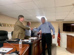 Piedmont University President Marshall Criser, right, shakes hands with City of Demorest Mayor Jerry Harkness following Tuesday's city council meeting. (Piedmont U. photo)