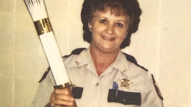 Goss holding the Olympic Torch inside the old courthouse in 1996. (Habersham Co. Sheriff's Office photo) 