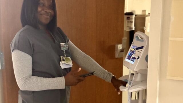 Oluwagbemisola Fernandez, a patient care technician at Northeast Georgia Medical Center (NGMC) Barrow, enters a patient room, prepared to use Chart with Art, Epic's new AI-powered tool. Staff are using this new technology to capture real-time conversations at all five NGMC hospitals. (NGHS photo)