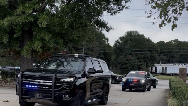 Processional with K9 Ann's body turns into Memorial Park Funeral Home and Cemetery in Gainesville Thursday. (HCSO)